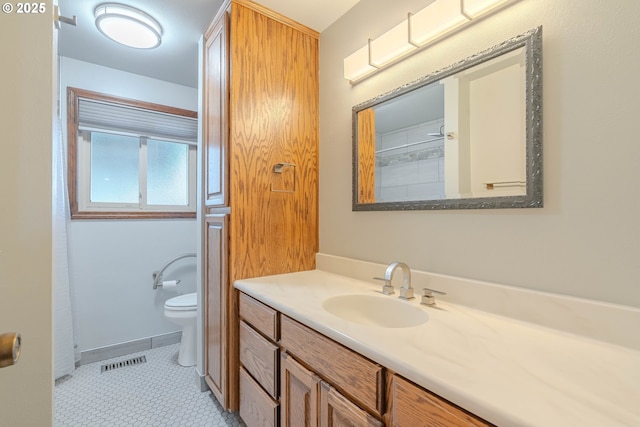 bathroom featuring toilet, tile patterned flooring, and vanity