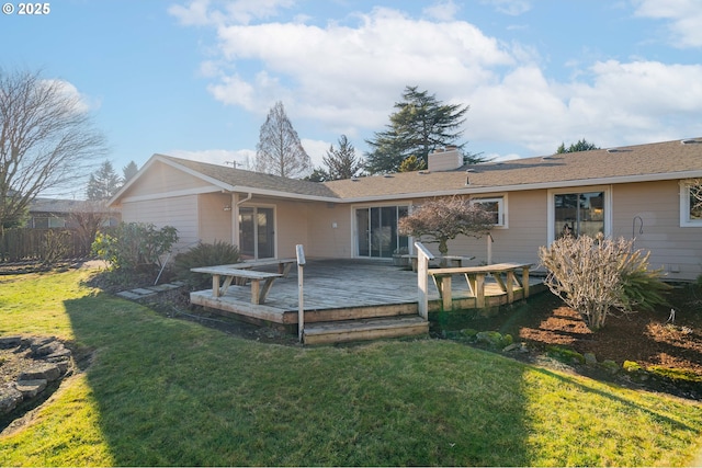 back of property with a yard and a wooden deck