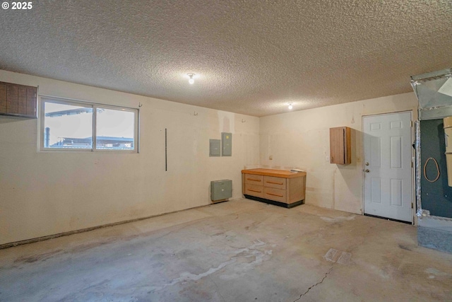 interior space featuring electric panel and a textured ceiling