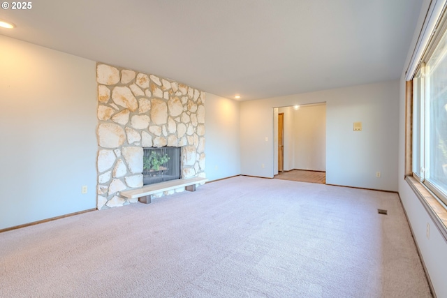 unfurnished living room featuring light carpet and a fireplace