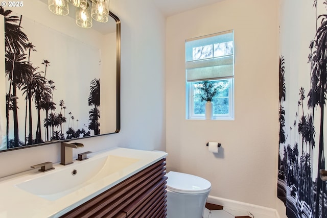 bathroom with vanity, a notable chandelier, and toilet