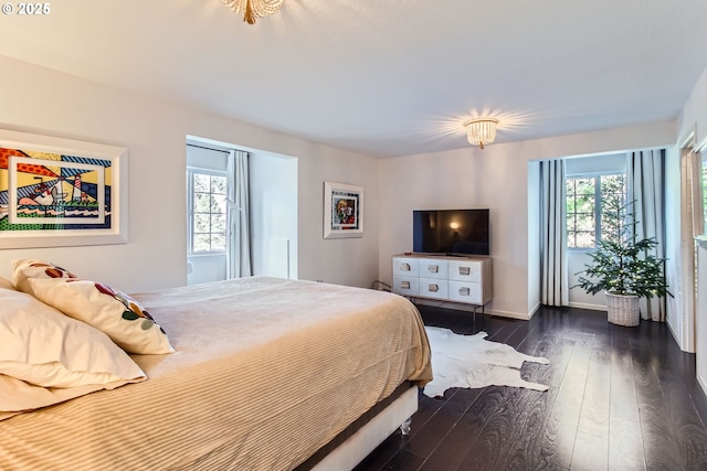 bedroom featuring multiple windows and dark hardwood / wood-style floors