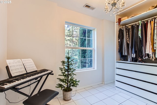 walk in closet featuring an inviting chandelier and light tile patterned flooring