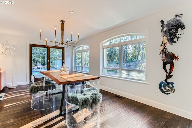 dining space with an inviting chandelier and dark wood-type flooring