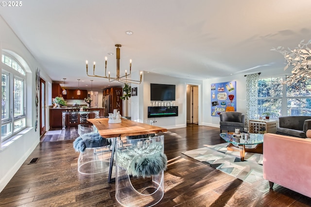 living room with a healthy amount of sunlight, dark hardwood / wood-style floors, and a chandelier