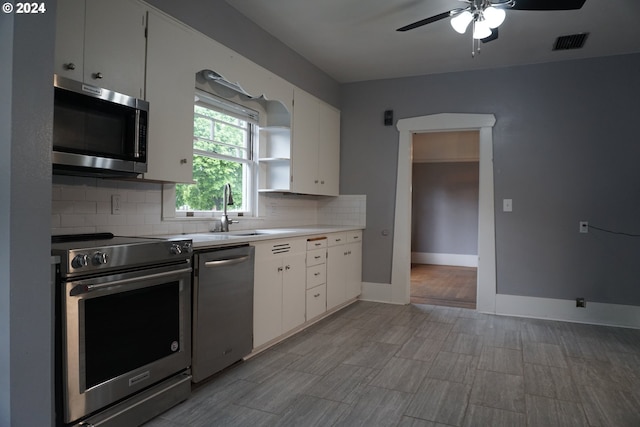 kitchen featuring backsplash, white cabinetry, and appliances with stainless steel finishes