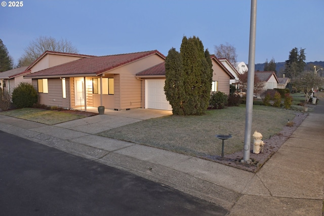 single story home featuring a yard and a garage