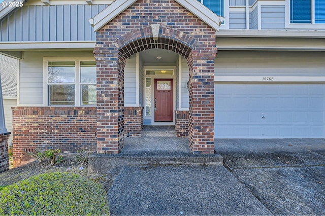 entrance to property with brick siding, board and batten siding, and concrete driveway