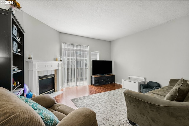 17364 SW Novato Ln, Beaverton, OR 97078 - living room featuring wood finished floors, a fireplace, and a textured ceiling