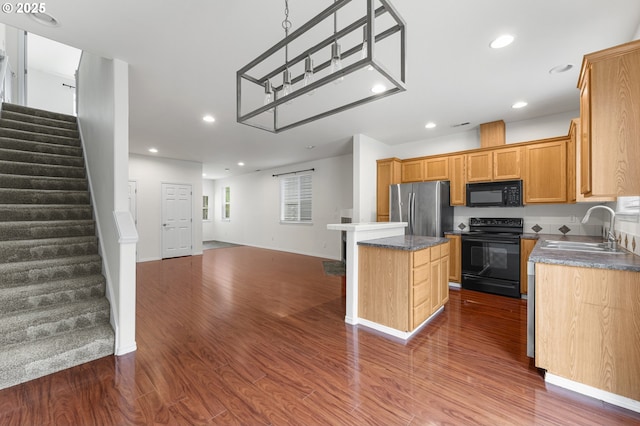 9234 SW Cascara Ln, Tualatin, OR 97062 - kitchen featuring black appliances, a sink, open floor plan, dark wood-style flooring, and a center island