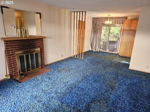 unfurnished living room featuring a brick fireplace, a textured ceiling, and dark colored carpet