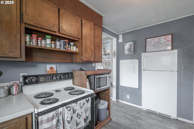2440 Porter St, Lebanon, OR 97355 - kitchen with white appliances, wood finished floors, light countertops, baseboards, and open shelves