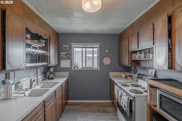 2440 Porter St, Lebanon, OR 97355 - kitchen featuring stainless steel microwave, white electric range, a sink, light countertops, and baseboards