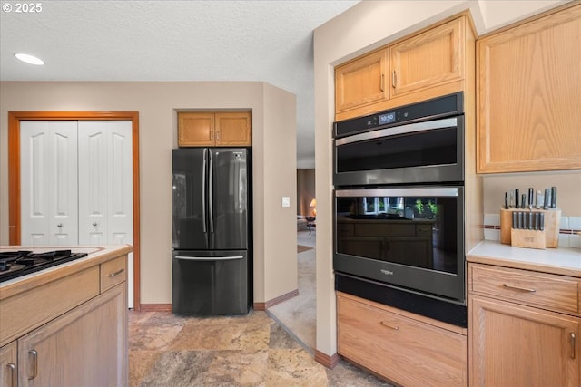 601 NW 110th Way, Vancouver, WA 98685 - kitchen with black appliances, light countertops, stone finish floors, light brown cabinetry, and a textured ceiling