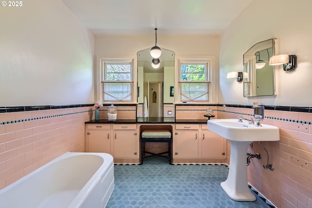 1834 SE 20th Ave, Portland, OR 97214 - bathroom with tile walls, a bath, plenty of natural light, and a wainscoted wall
