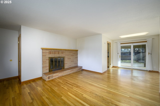 1736 NE Hembree St, Mcminnville, OR 97128 - unfurnished living room featuring wood finished floors, a brick fireplace, and baseboards