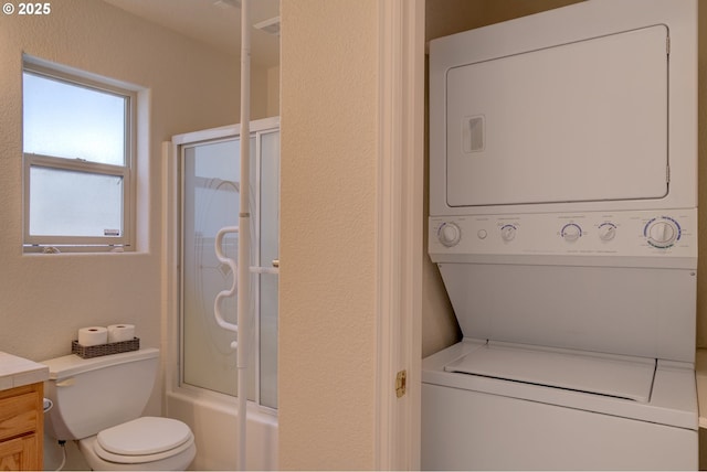 315 5th St NW Unit 101, Long Beach, WA 98631 - full bath with stacked washer / drying machine, vanity, a textured wall, and bath / shower combo with glass door