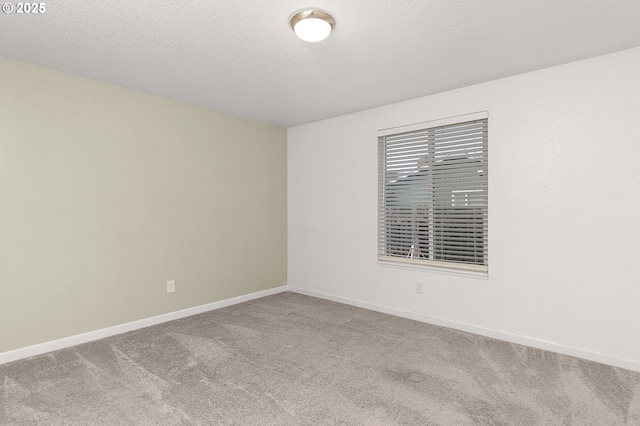 carpeted empty room with a textured ceiling