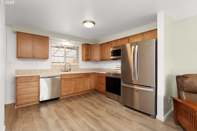 kitchen featuring light wood-type flooring, appliances with stainless steel finishes, and sink