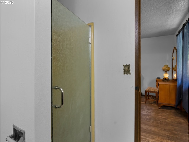 hallway with a textured ceiling and dark wood-style flooring