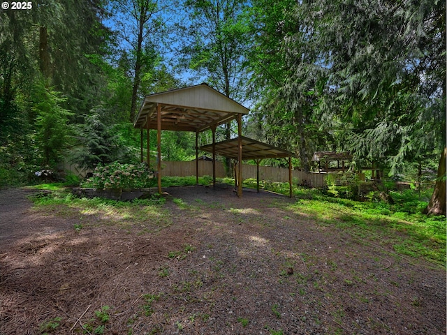 view of yard featuring fence and a carport