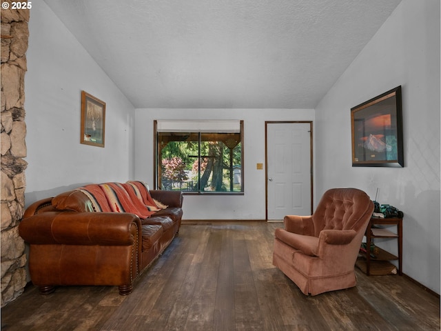 living area with a textured ceiling, lofted ceiling, and hardwood / wood-style floors