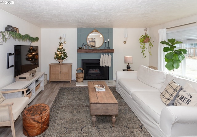 living room featuring wood-type flooring and a textured ceiling