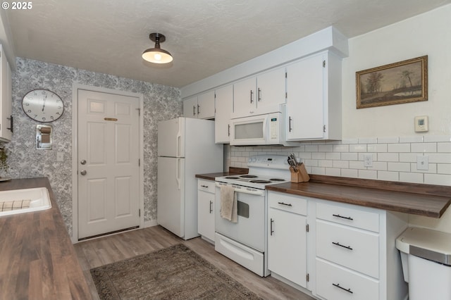 kitchen with wood counters, white cabinetry, wood-type flooring, and white appliances