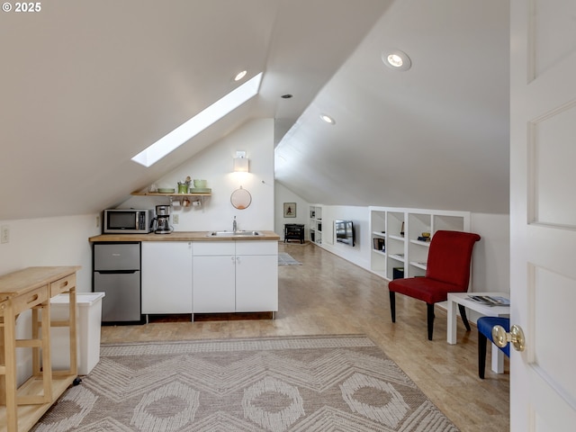 1630 SE 46th Ave, Portland, OR 97215 - kitchen featuring a skylight, stainless steel appliances, built in features, white cabinets, and lofted ceiling