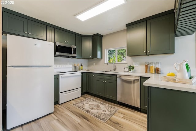 2251 SE 139th Ave, Portland, OR 97233 - kitchen with appliances with stainless steel finishes, green cabinets, light countertops, and light wood finished floors