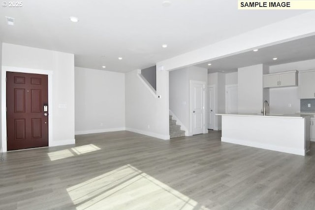 unfurnished living room featuring light hardwood / wood-style flooring and sink