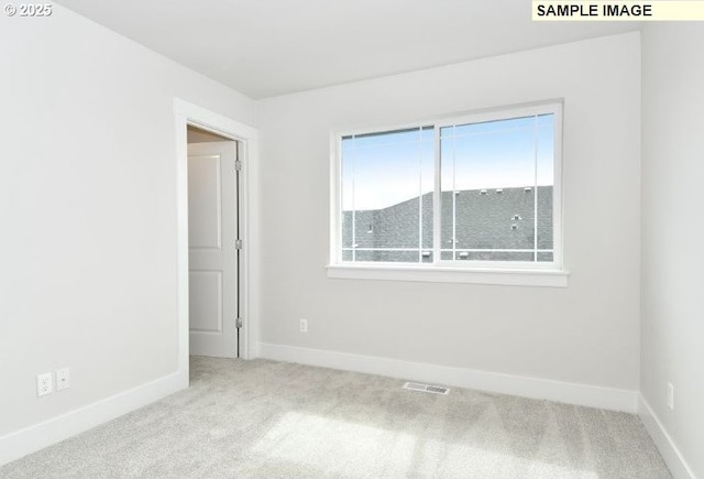 spare room featuring light colored carpet