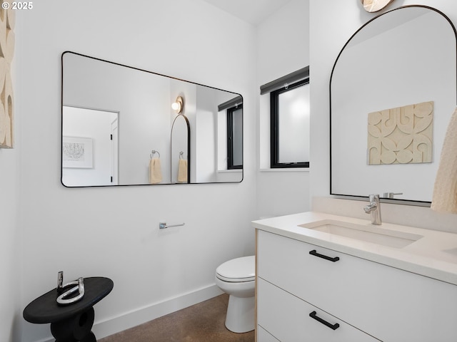 bathroom with baseboards, toilet, and vanity
