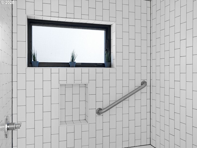 full bath with a tile shower and healthy amount of natural light