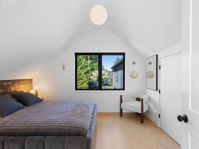 bedroom with lofted ceiling, light colored carpet, and baseboards