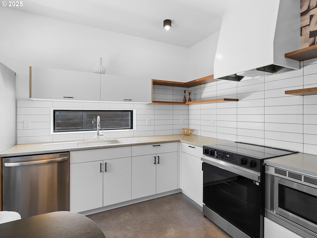 kitchen with stainless steel appliances, open shelves, wall chimney range hood, a sink, and backsplash