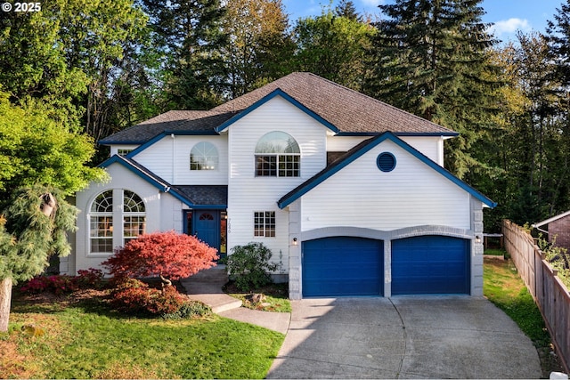 view of front of home with concrete driveway, fence, a shingled roof, and a garage