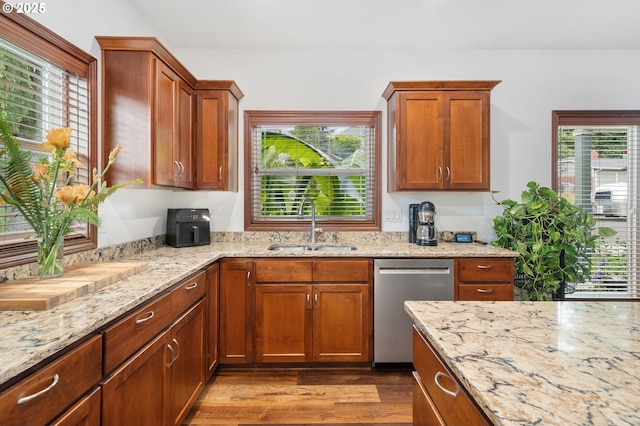 23072 SW Mansfield St, Sherwood, OR 97140 - kitchen featuring stainless steel dishwasher, a sink, dark wood-style flooring, light stone countertops, and brown cabinetry