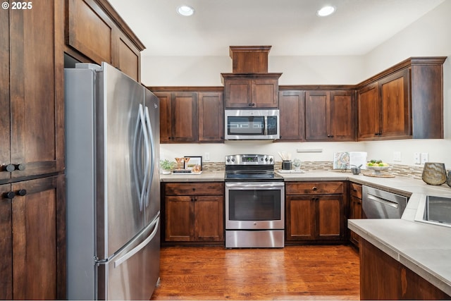 16125 SE Kingbird Dr, Clackamas, OR 97015 - kitchen with stainless steel appliances, light countertops, recessed lighting, dark wood-type flooring, and dark brown cabinetry