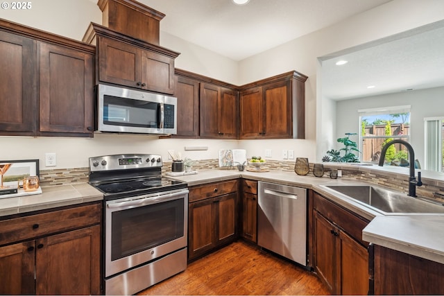 16125 SE Kingbird Dr, Clackamas, OR 97015 - kitchen featuring appliances with stainless steel finishes, a sink, wood finished floors, recessed lighting, and dark brown cabinetry