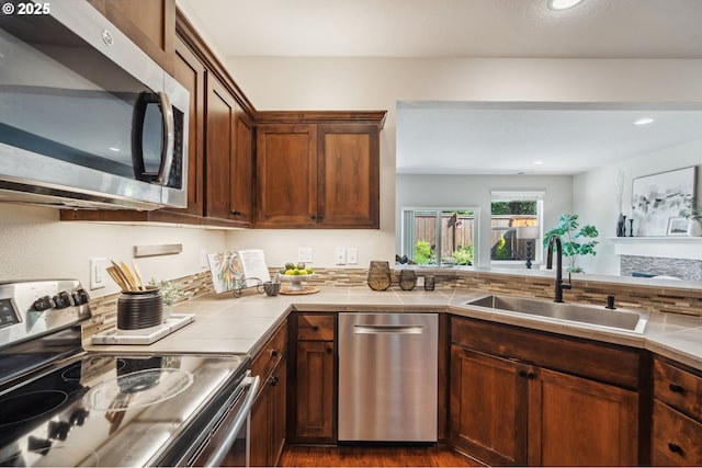 16125 SE Kingbird Dr, Clackamas, OR 97015 - kitchen with stainless steel appliances, a sink, dark wood-style flooring, tile counters, and recessed lighting