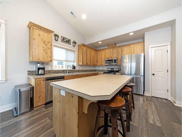 1058 E 16th St, Lafayette, OR 97127 - kitchen featuring stainless steel appliances, a kitchen island, lofted ceiling, dark wood-type flooring, and light countertops
