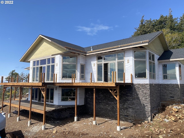 back of property featuring a deck and a sunroom