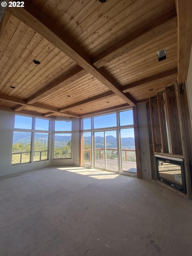 spare room with expansive windows, wooden ceiling, and beam ceiling