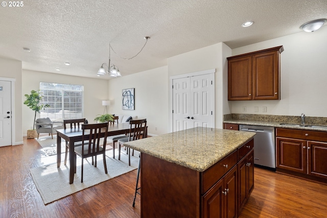 kitchen featuring stainless steel dishwasher, dark wood-style flooring, a sink, and a center island