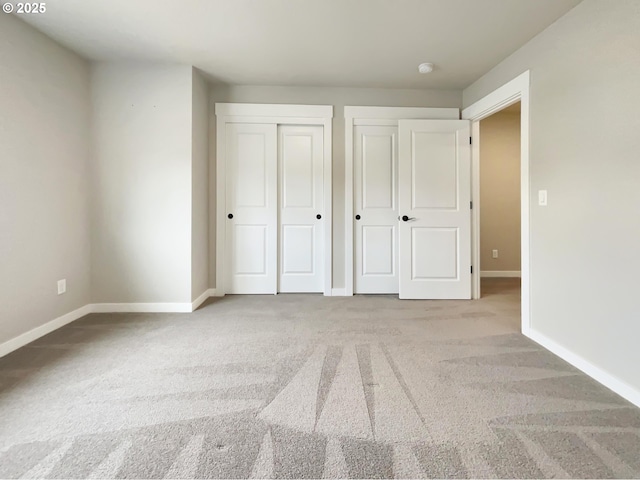 unfurnished bedroom with light carpet and baseboards