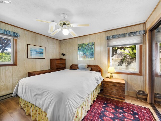 bedroom featuring multiple windows, wood finished floors, and crown molding