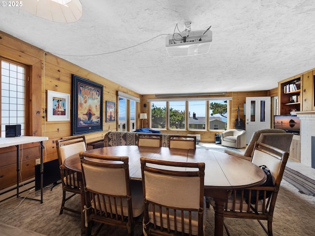 dining area with wooden walls and a textured ceiling