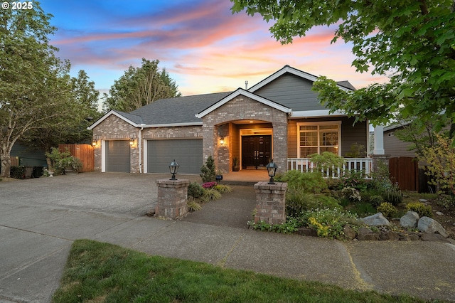 16904 SW Stellar Dr, Sherwood, OR 97140 - view of front of house with covered porch, a garage, concrete driveway, brick siding, and a shingled roof