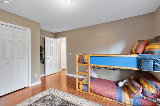 16904 SW Stellar Dr, Sherwood, OR 97140 - bedroom with wood finished floors, baseboards, a textured ceiling, and a closet